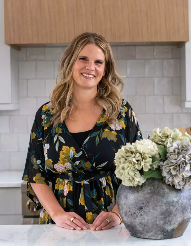 Amy Pottenger, founder of Refresh Design, in a bright white kitchen