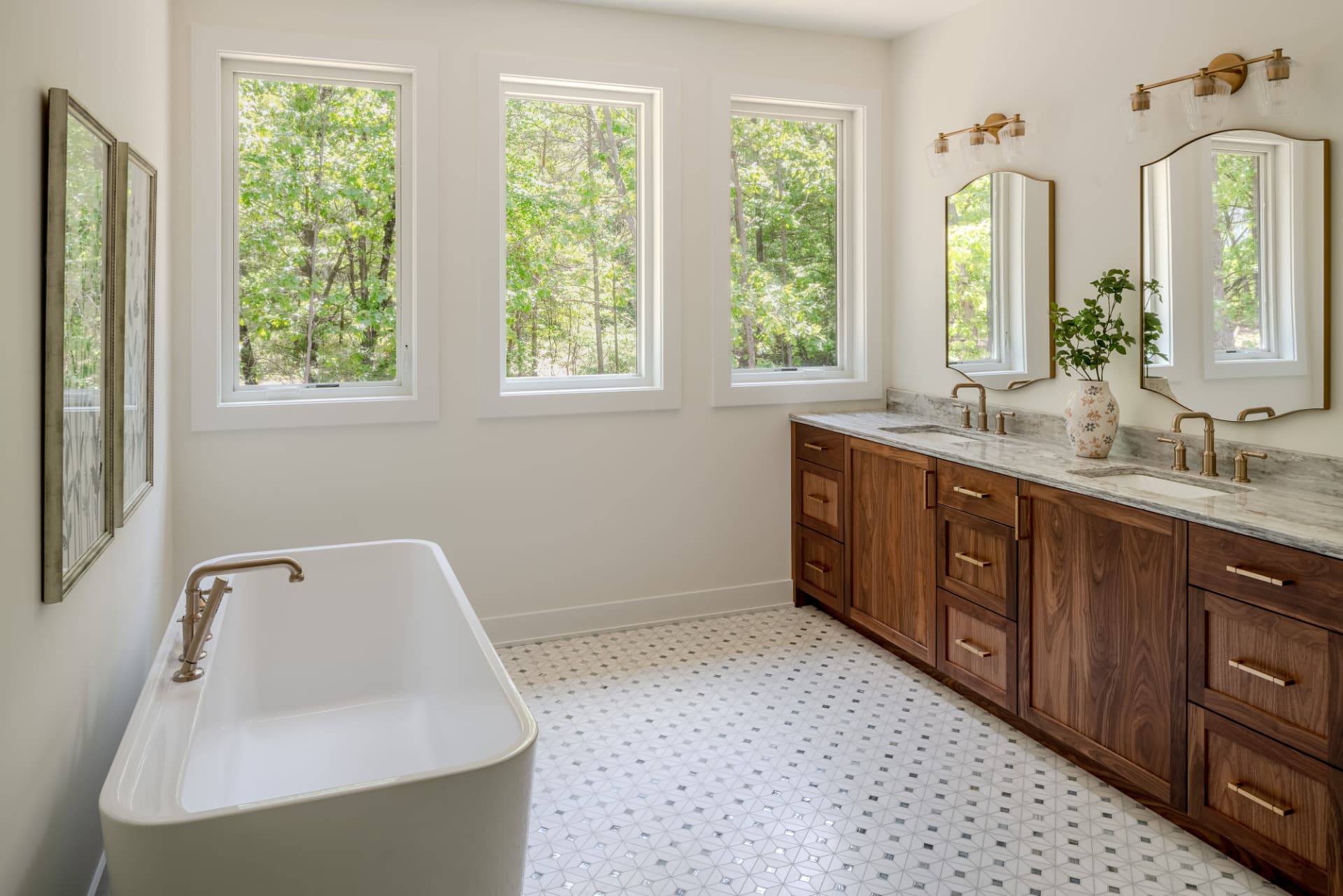 Primary bath with walnut double vanity, freestanding tub and mosaic tile floor
