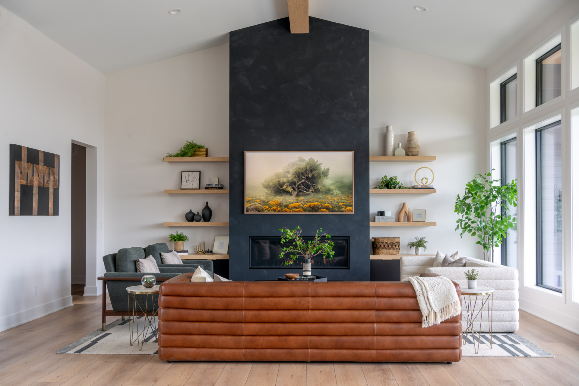 Vaulted living room with black plaster fireplace, oak shelving and a leather sofa
